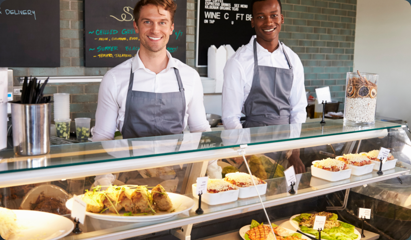 Deli counter staff behind a prepared foods case