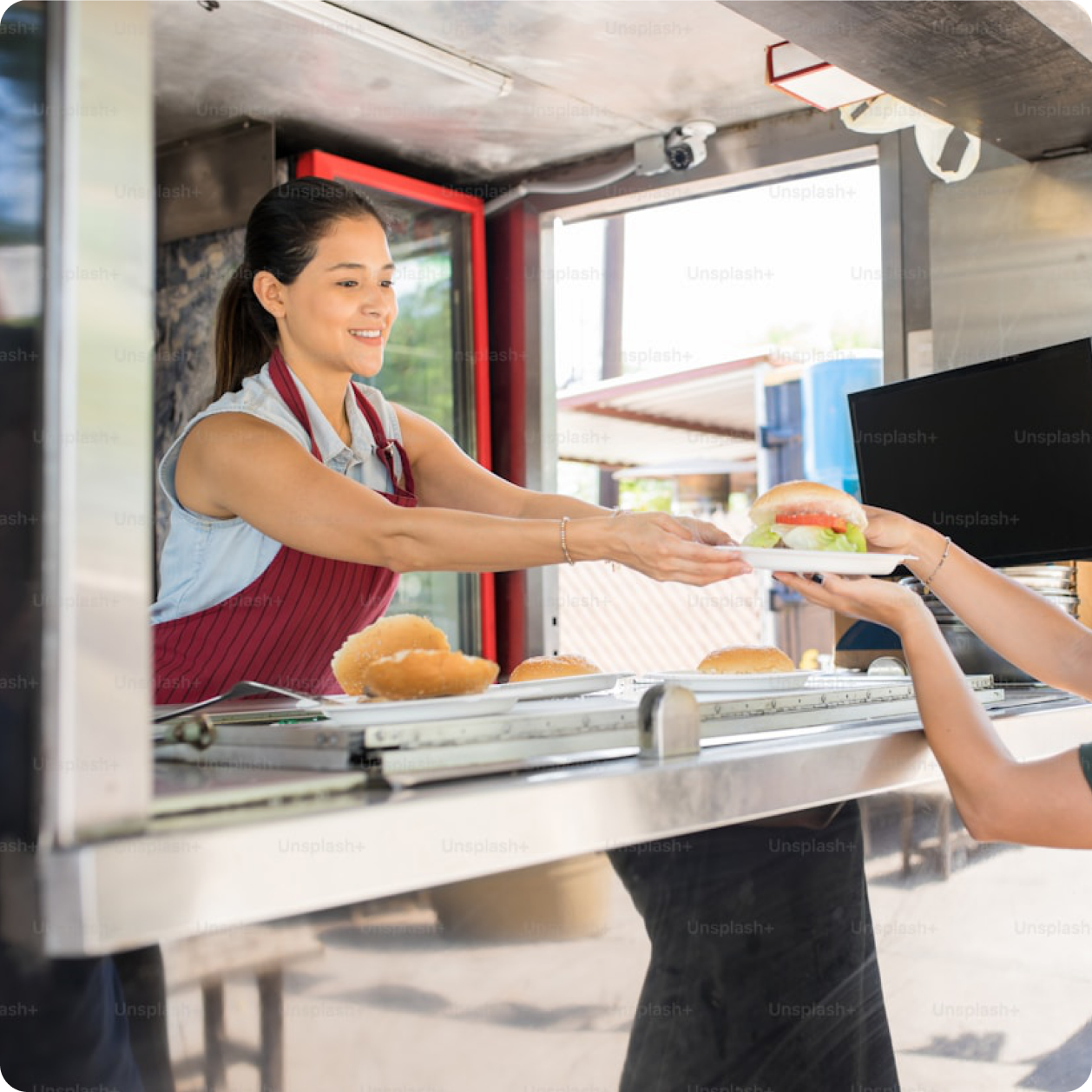 Food truck staff serving a burger to a customer